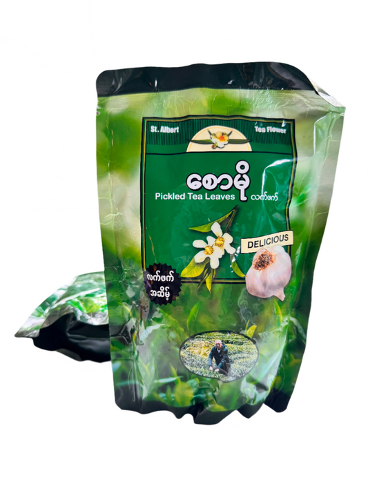 Packaged pickled tea leaves with branding on a white surface